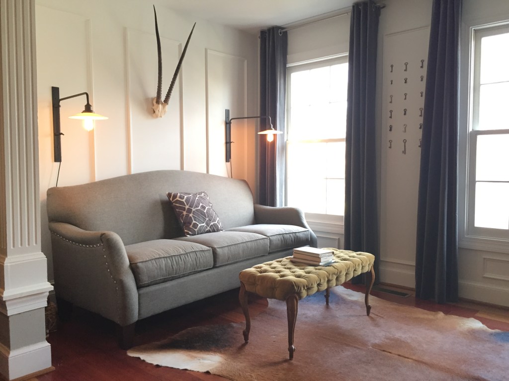 A sitting room that we accented with a vintage velvet tufted table, some gemsbok horns, and 18 aluminum keys from WWII-era Germany. Little details go a long way!