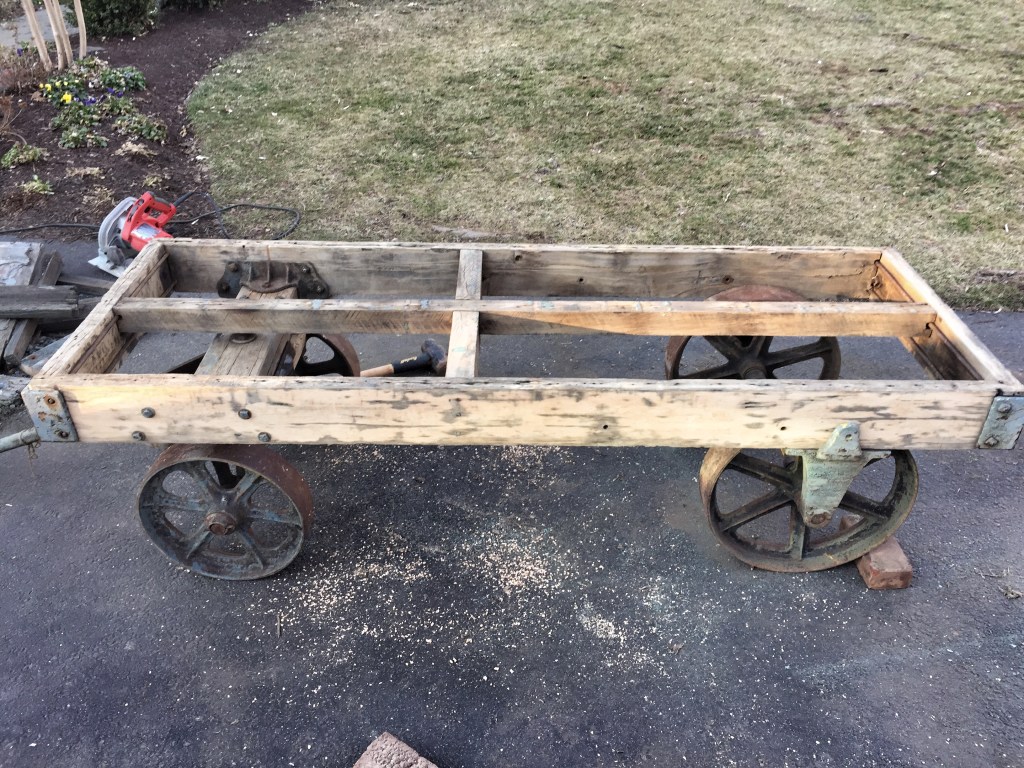 Cart after rotted wood was removed, frame shortened, power-washed and sanded. I love the hand-hewn cross beam in the middle.